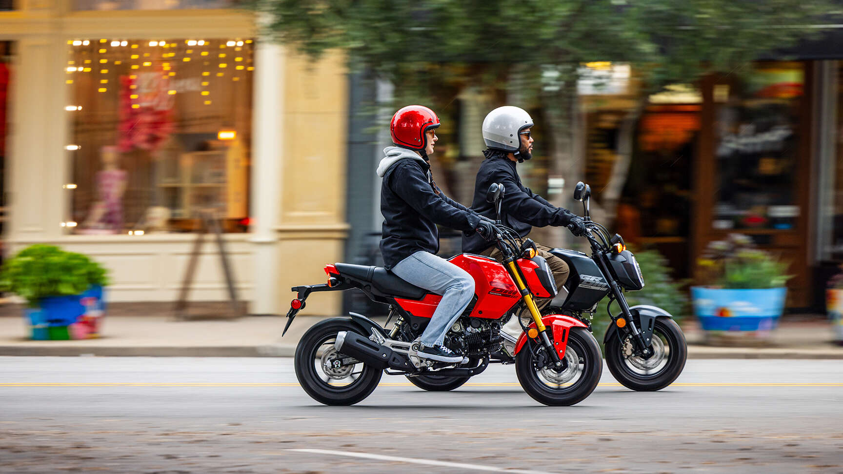 MSX125 Grom feketében és vörösben egy városon halad át